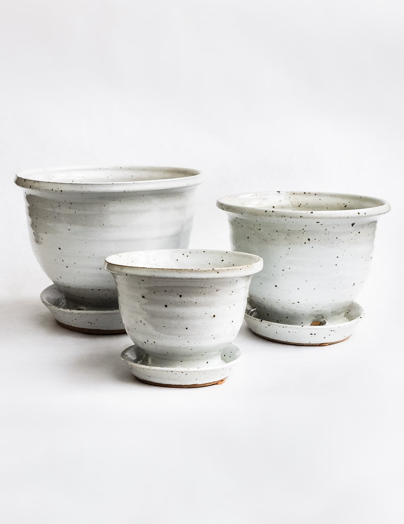 Handcrafted white speckled pots with attached drainage tray on white background