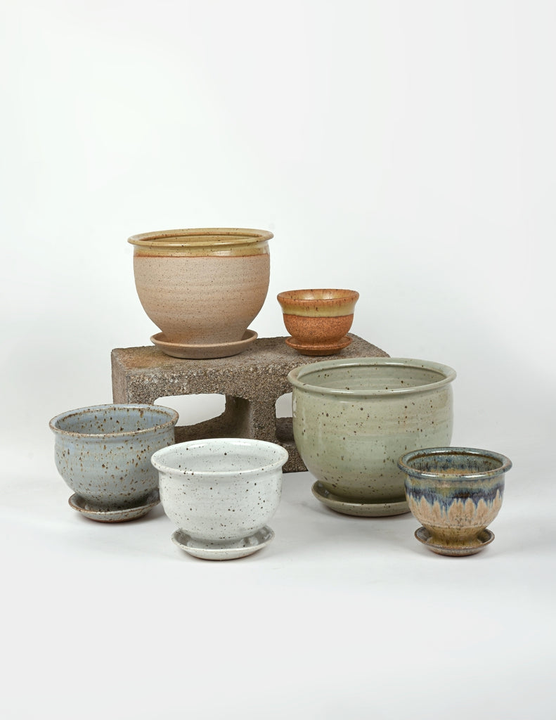 Grouping of pots of various sizes and colors with white background