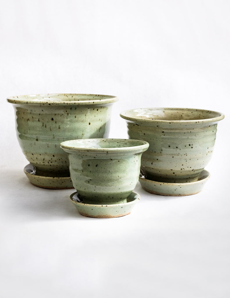 Handcrafted natural green speckled pots with attached drainage tray on white background
