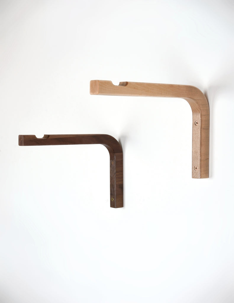 Birch and Walnut L-shaped wall brackets attached to white wall with screws